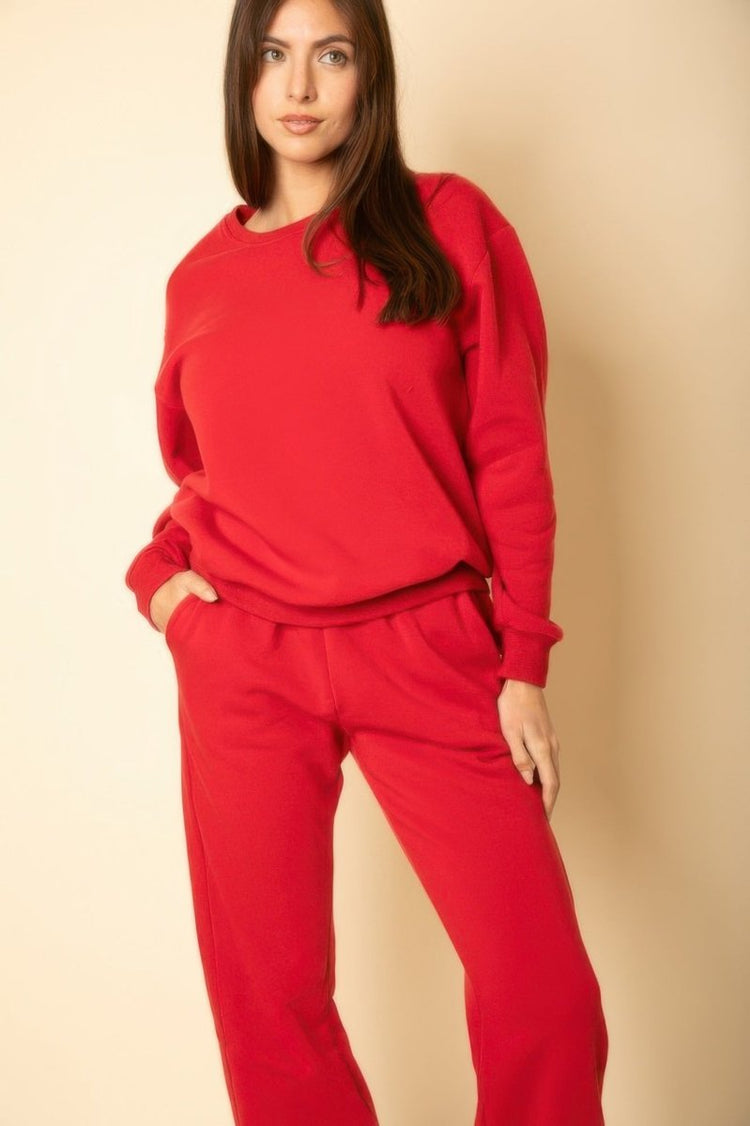 Woman wearing a red outfit against a beige background