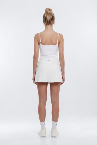 Person wearing a white dress on a plain background