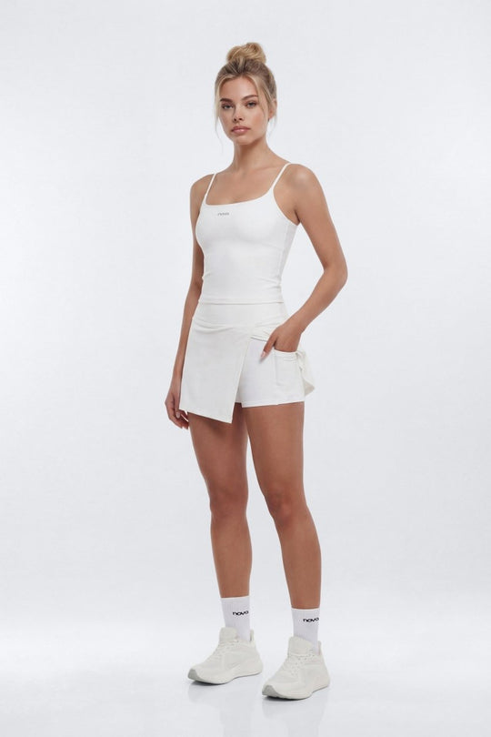 Woman wearing a white tank top and shorts on a white background