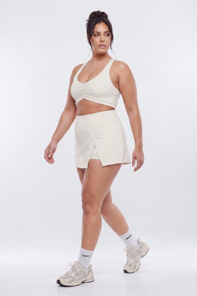 Woman wearing a white athletic outfit on a white background