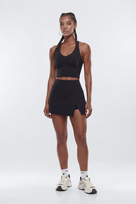 Woman wearing a black athletic outfit on a white background
