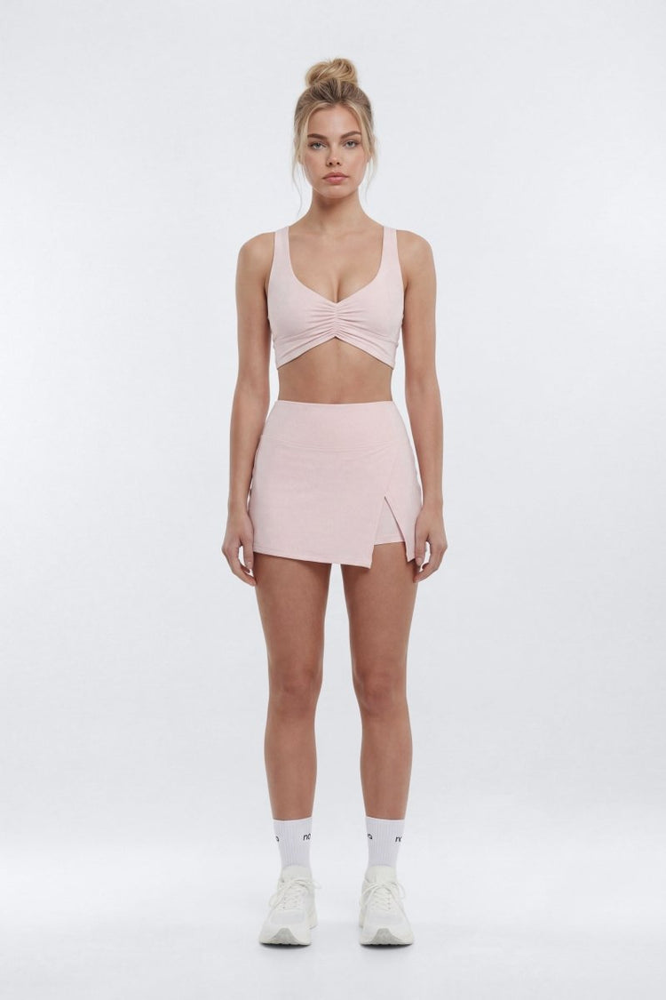Woman wearing a pink athletic outfit on a white background