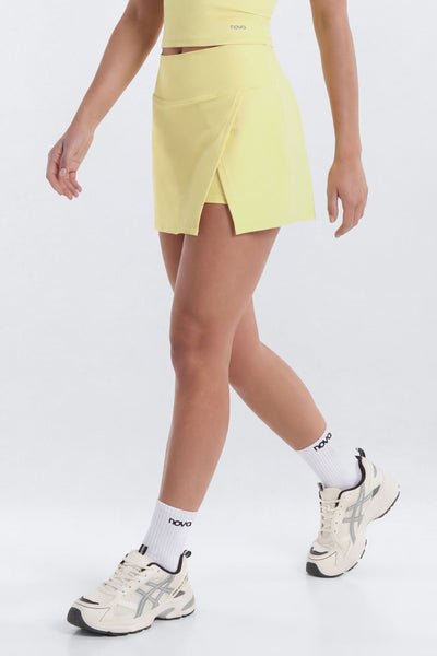 Person wearing a yellow skirt, white socks, and sneakers on a white background