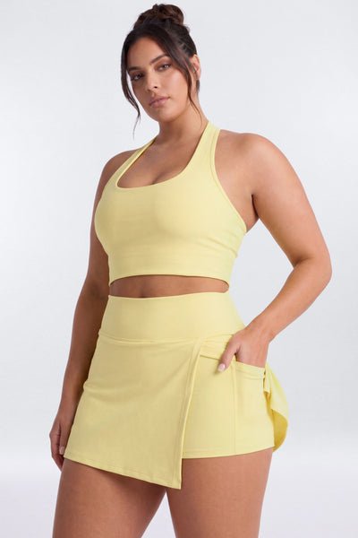 Woman wearing a yellow athletic outfit on a white background