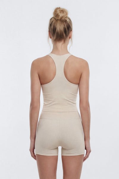 Person wearing a beige romper on a white background