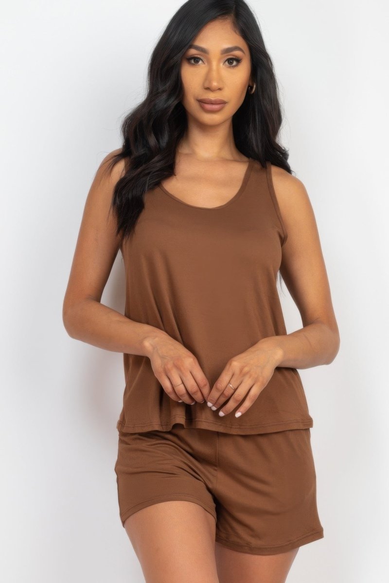 Woman wearing a brown sleeveless top and shorts set on a white background