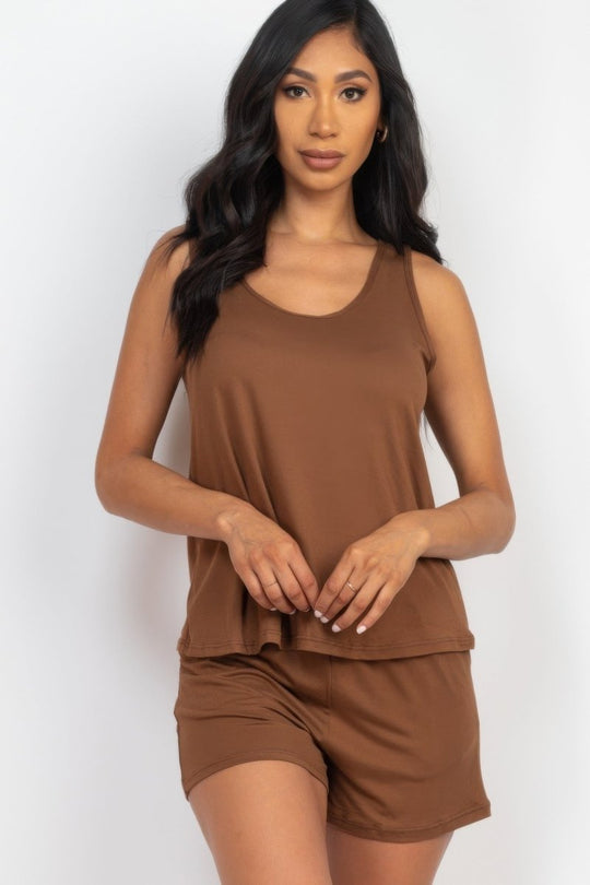 Woman wearing a brown sleeveless top and shorts set on a white background