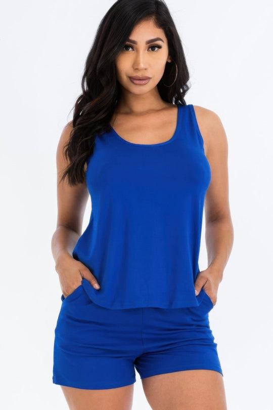 Woman wearing a blue sleeveless top and shorts on a white background