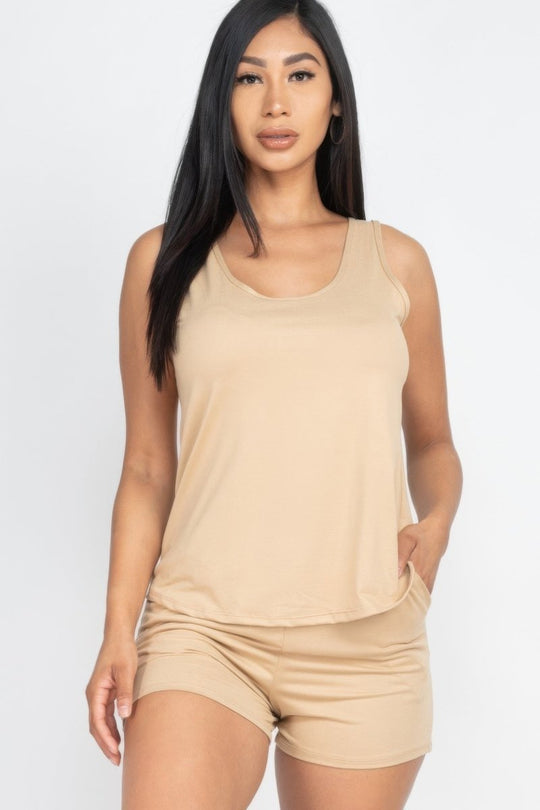 Woman wearing a beige tank top and shorts set on a white background