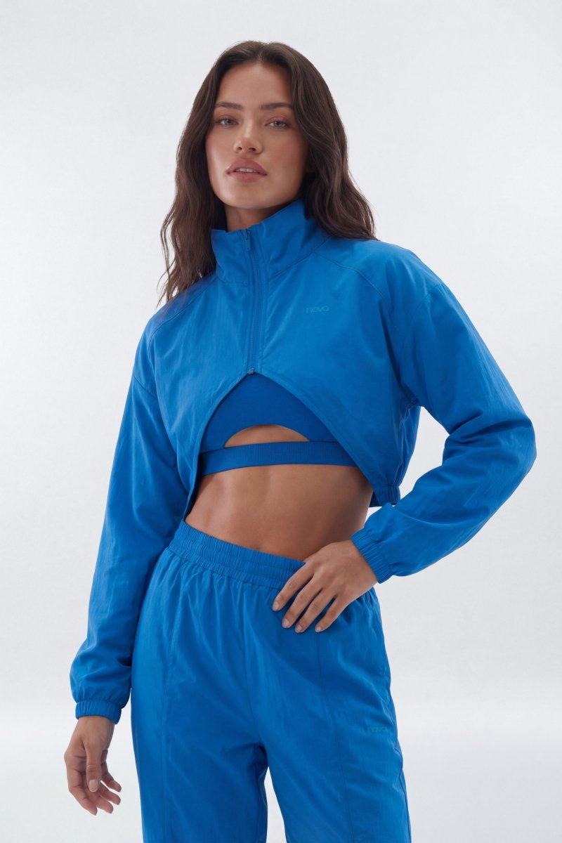 Woman wearing a blue tracksuit on a white background
