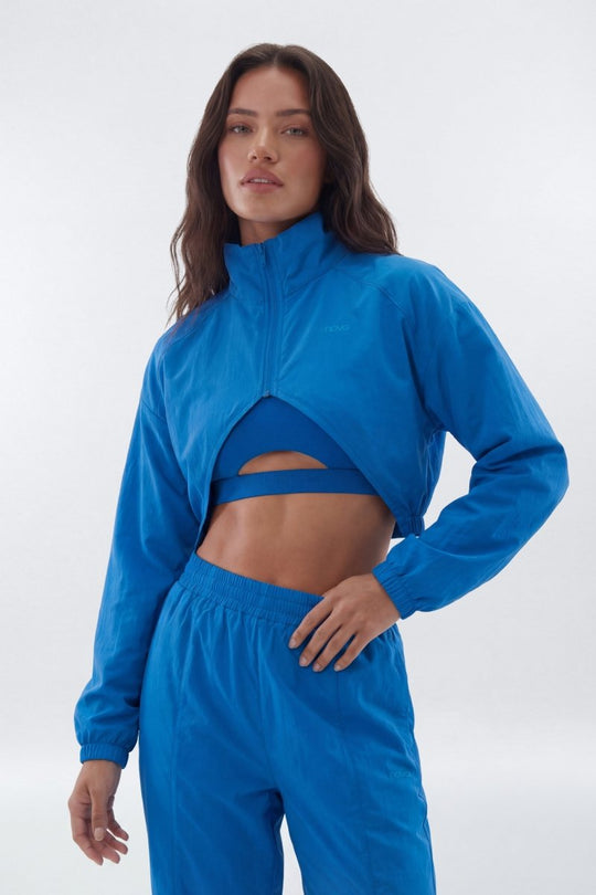 Woman wearing a blue tracksuit on a white background