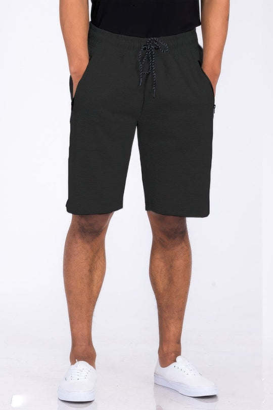 Person wearing black shorts on a white background