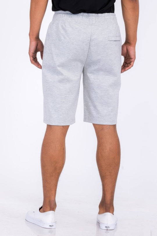 Person wearing gray shorts on a white background