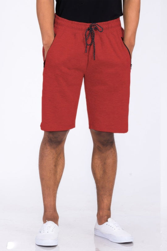 Red shorts worn by a person on a white background