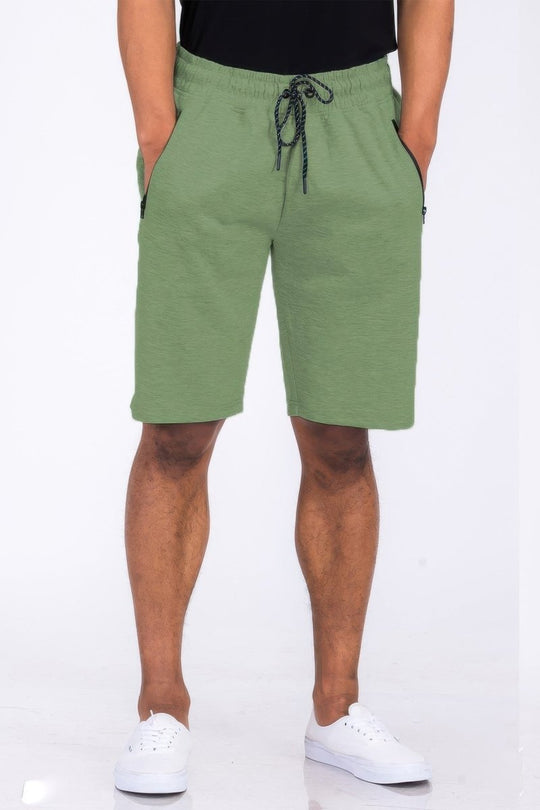 Person wearing green shorts on a white background