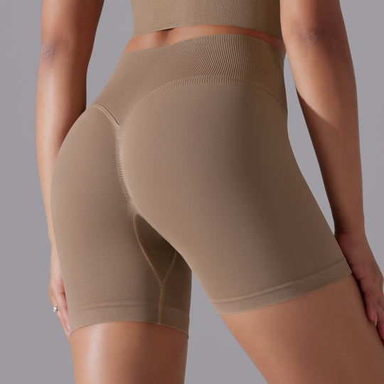 Beige athletic shorts worn by a person on a gray background