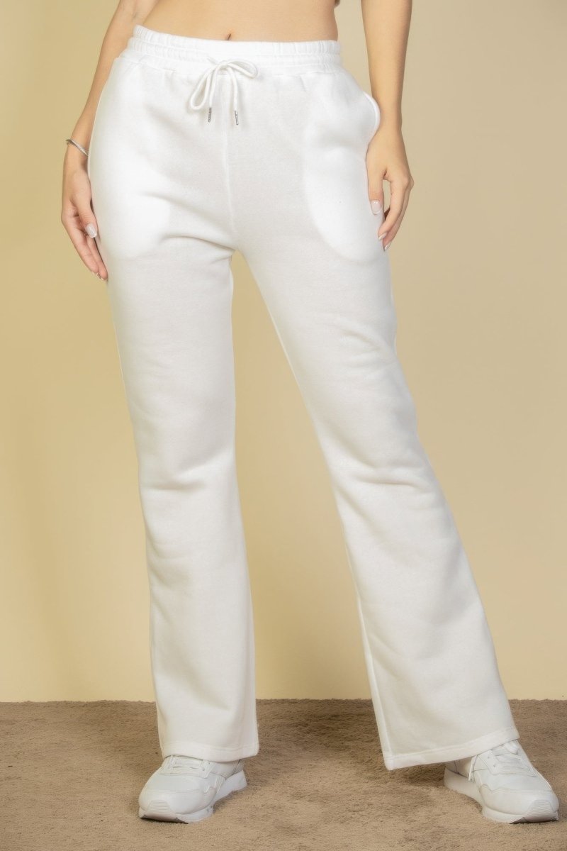 White pants worn by a person on a beige background