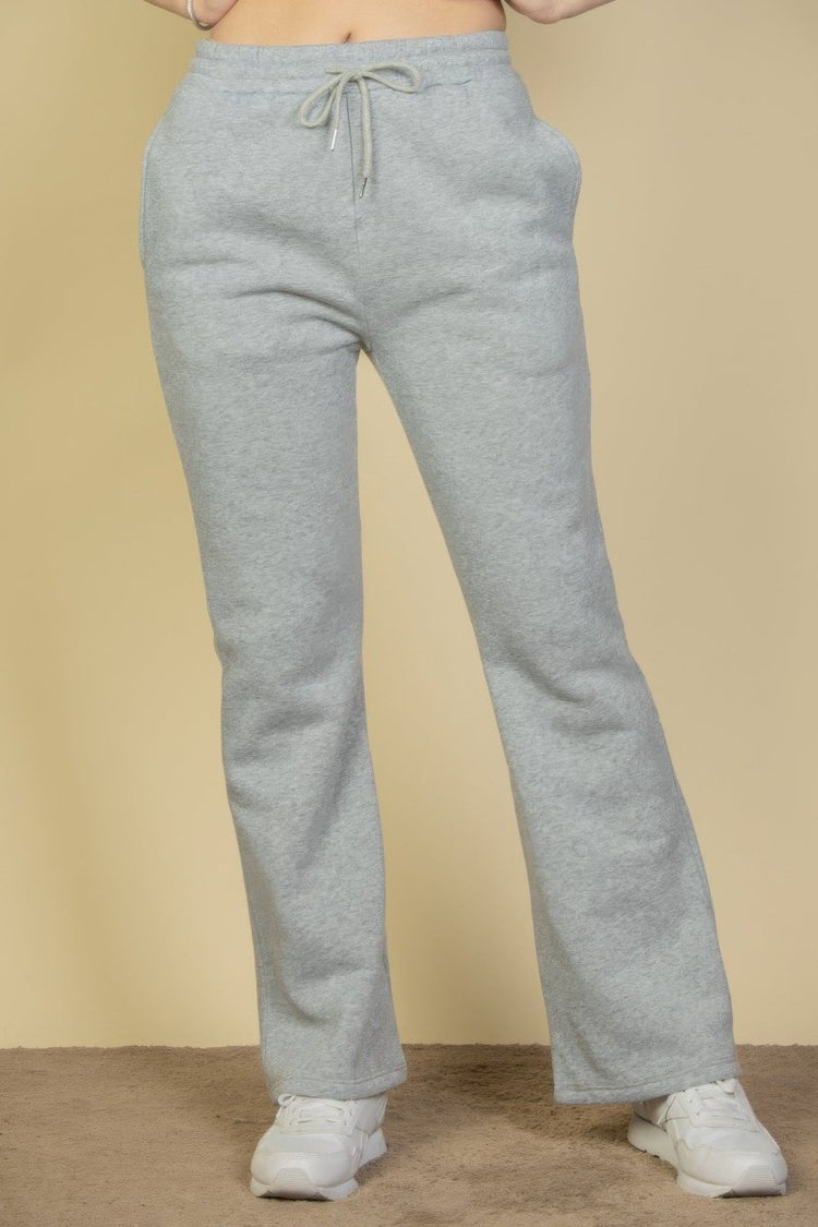 Gray sweatpants worn by a person on a beige background