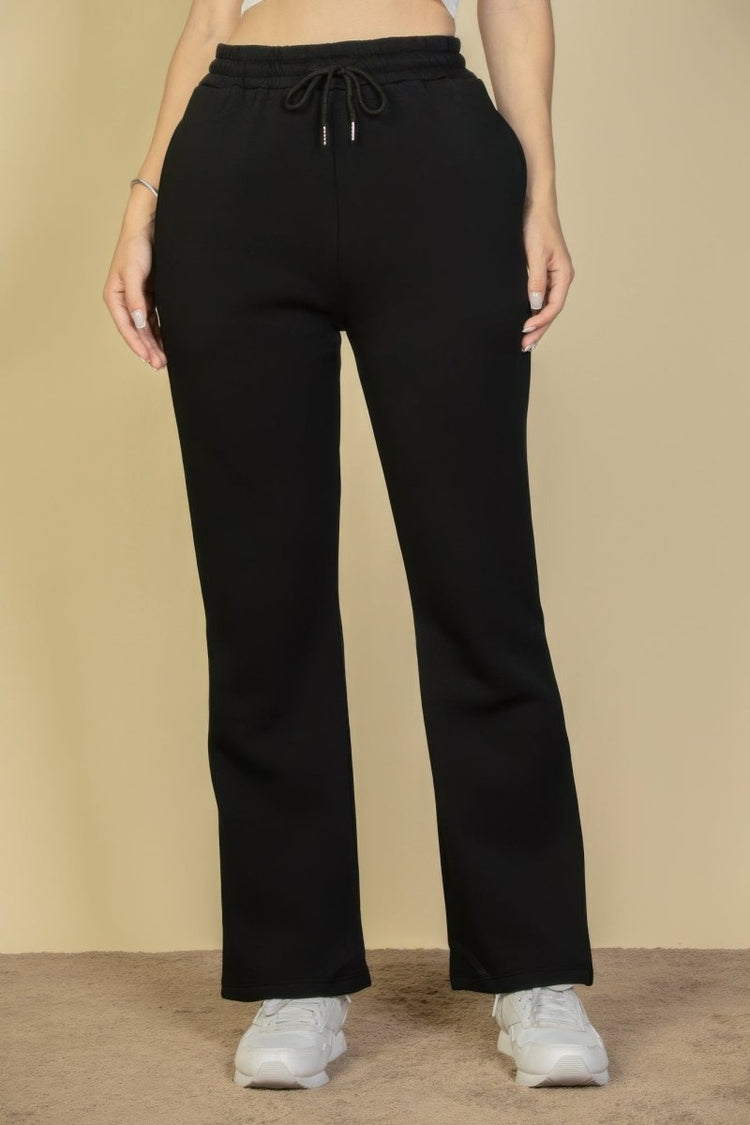 Black pants worn by a person on a beige background