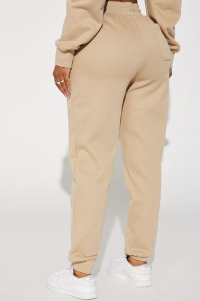 Beige sweatpants worn with a white background