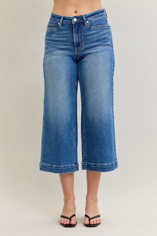 Blue jeans worn by a person on a plain background