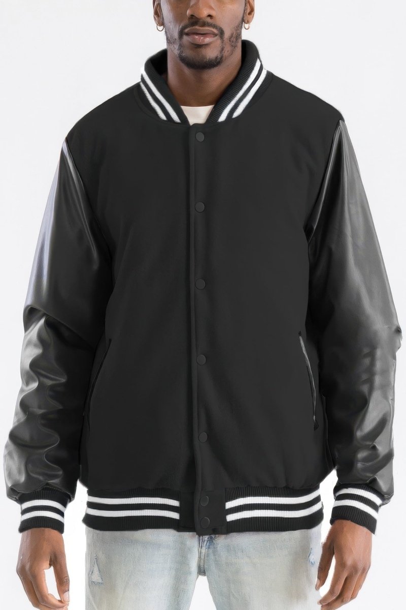 Black varsity jacket with leather sleeves worn by a person on a white background