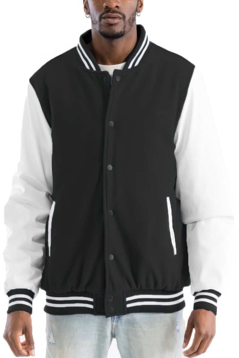 Man wearing a black and white varsity jacket on a white background