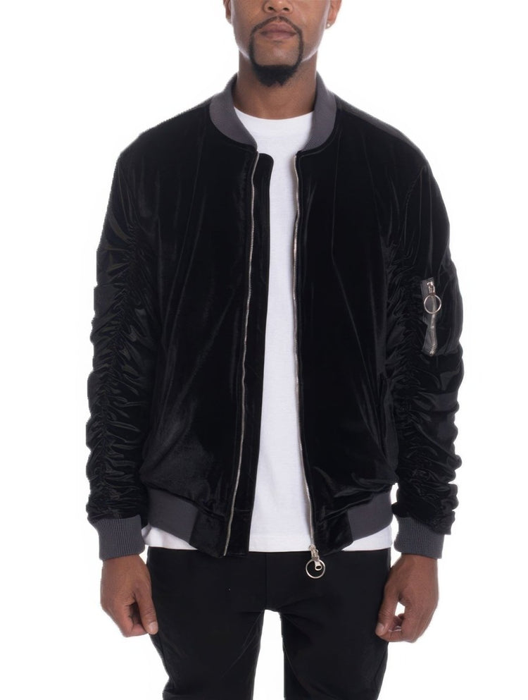 Man wearing a black bomber jacket with gray accents on a white background