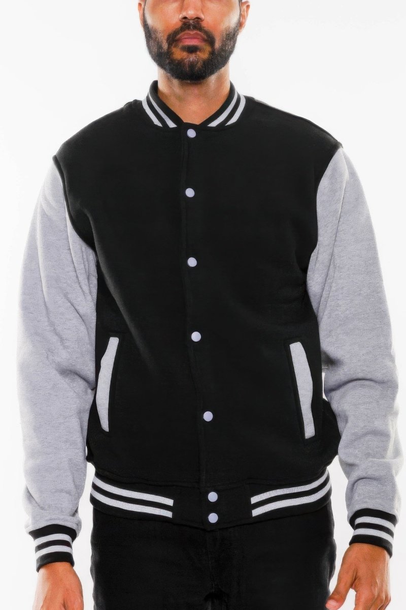 Man wearing a black and gray varsity jacket on a white background