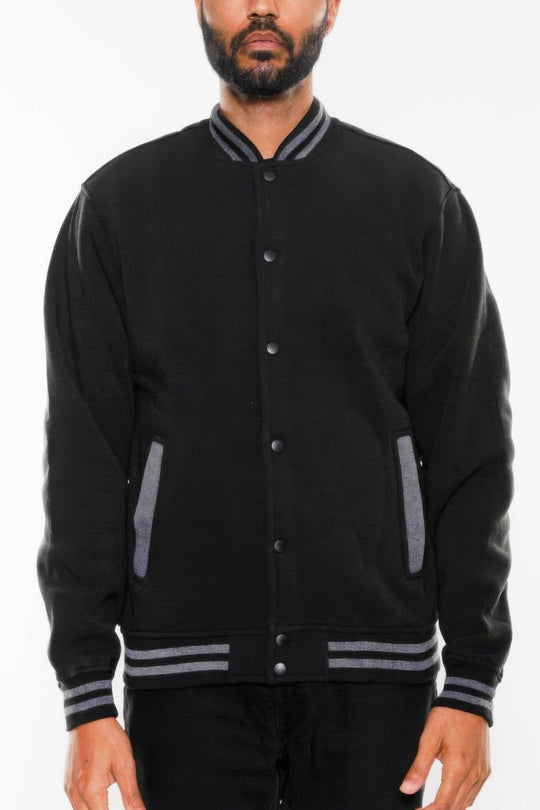 Black varsity jacket with gray accents worn by a person on a white background
