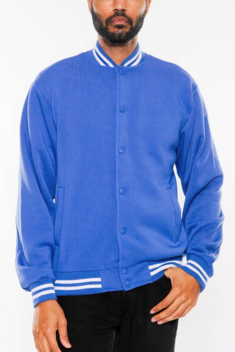 Person wearing a blue varsity jacket with white accents on a white background