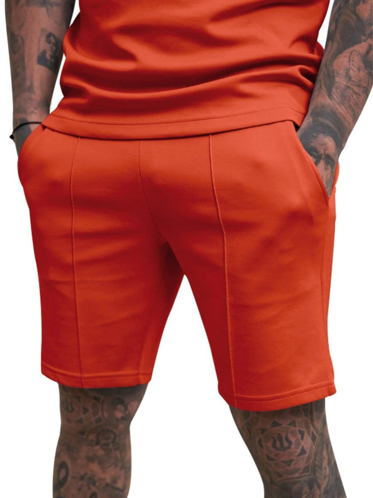 Person wearing bright orange shorts on a white background