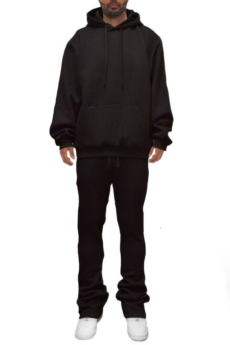 Person wearing a black hoodie and pants on a white background