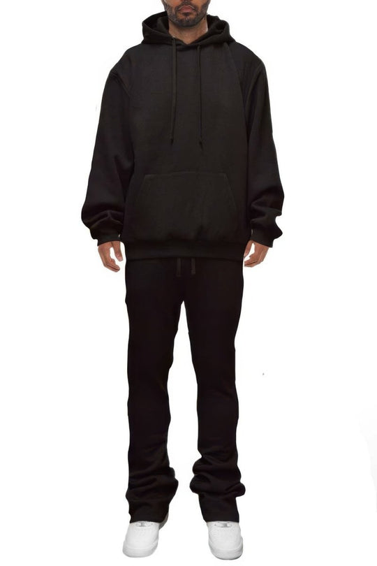 Person wearing a black hoodie and pants on a white background