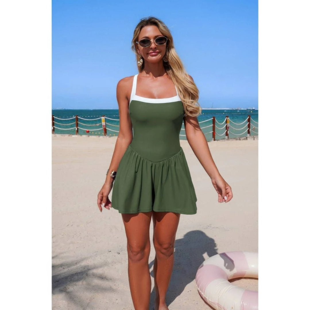 Woman in a green swimsuit standing on a beach with ocean view