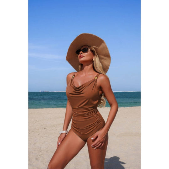 Woman in a brown swimsuit and sun hat on a beach