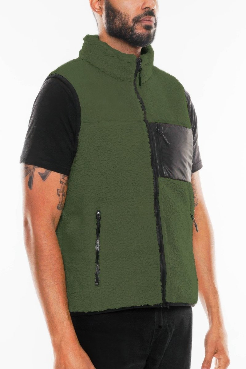 Man wearing a green and black vest on a white background