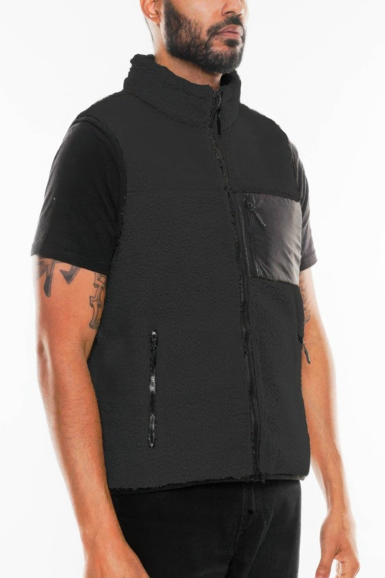 Man wearing a black and gray vest on a white background
