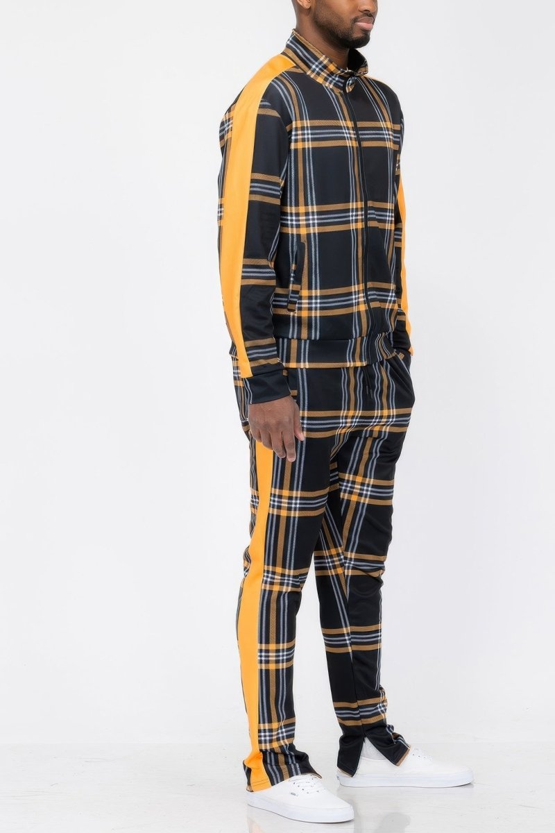 Person wearing a black and yellow plaid outfit with white sneakers on a white background
