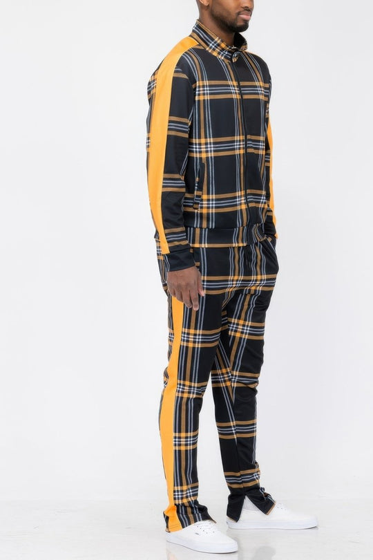 Person wearing a black and yellow plaid outfit with white sneakers on a white background