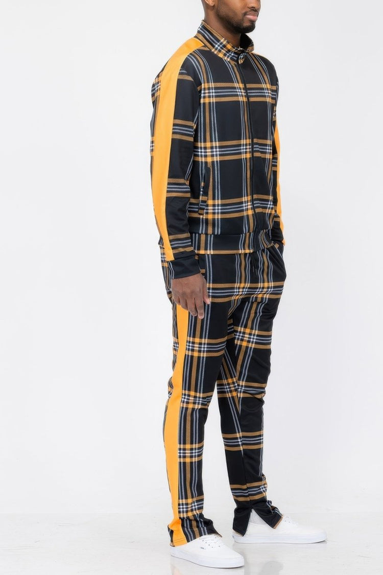 Person wearing a black and yellow plaid outfit with white sneakers on a white background