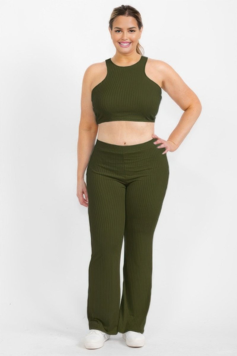 A woman modeling a matching ribbed two-piece activewear set in olive green, featuring a sleeveless crop top and high-waisted flared pants, against a plain white studio background.