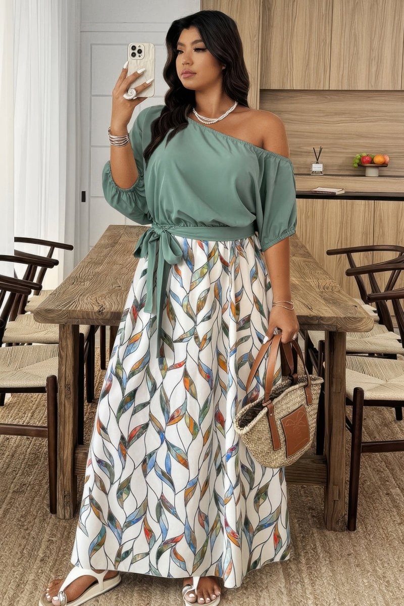 Woman taking a selfie in a stylish dress with a patterned skirt and green top in a dining area.