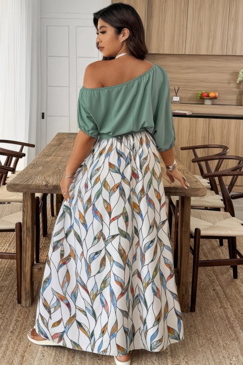 Woman in a green top and patterned skirt standing in a kitchen.