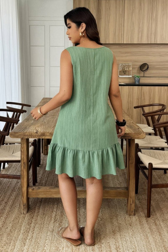 Woman in a green dress standing in a restaurant setting