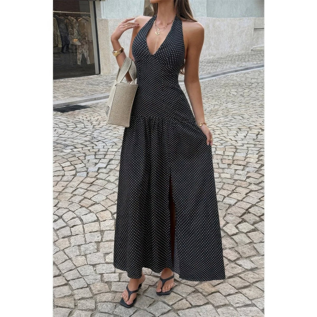Woman wearing a black polka dot dress on a cobblestone street.