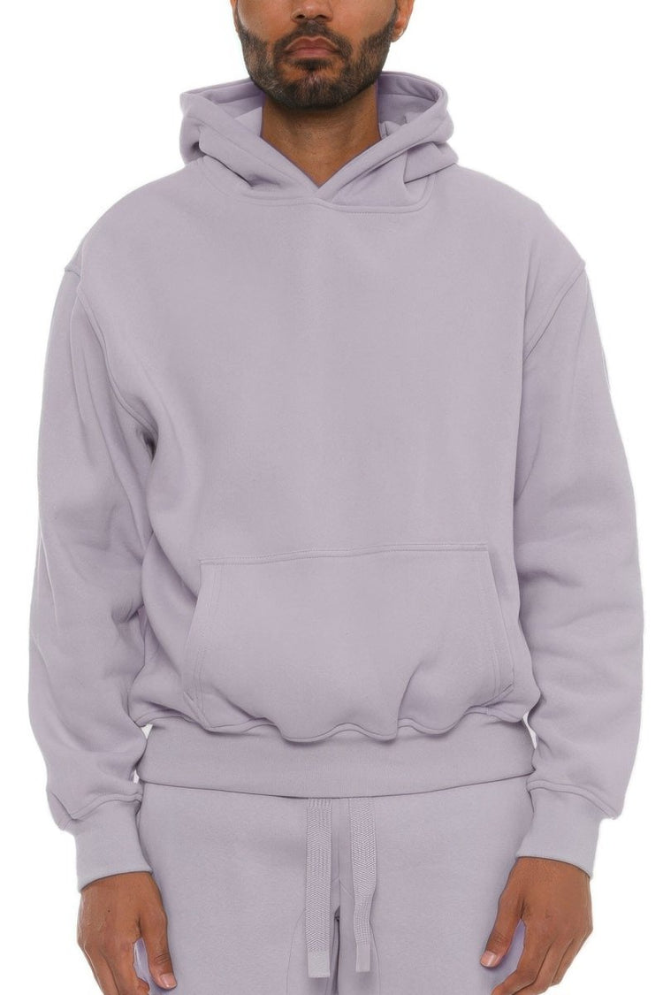 Man wearing a light purple hoodie and pants on a white background