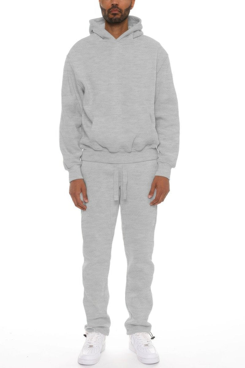 Person wearing a gray tracksuit on a white background