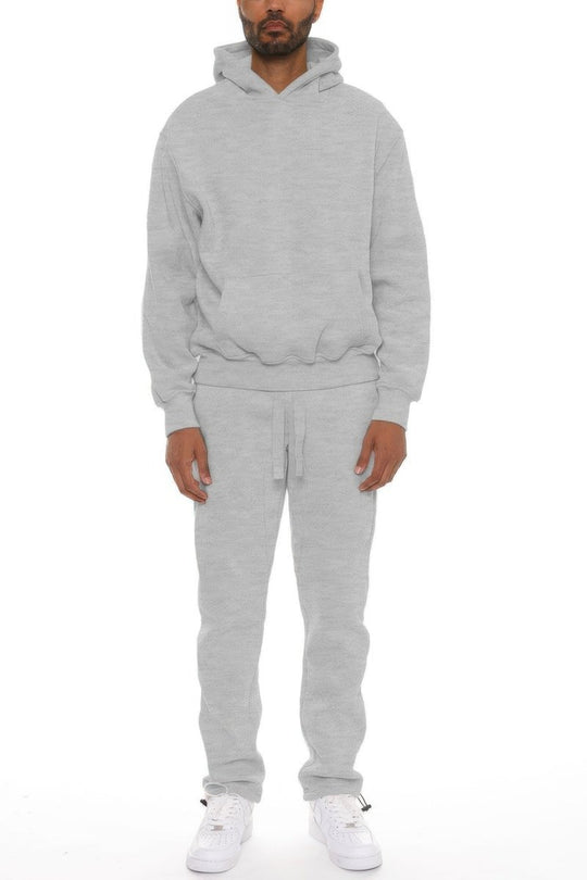 Person wearing a gray tracksuit on a white background
