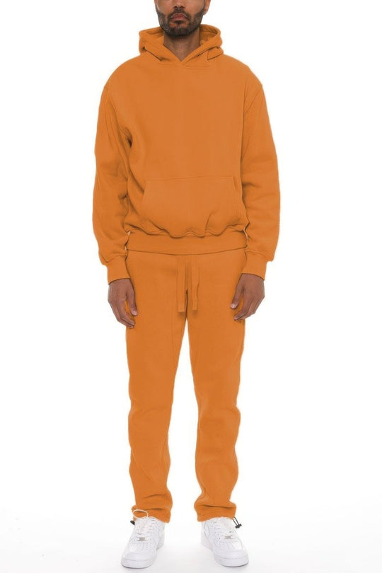Person wearing an orange tracksuit on a white background